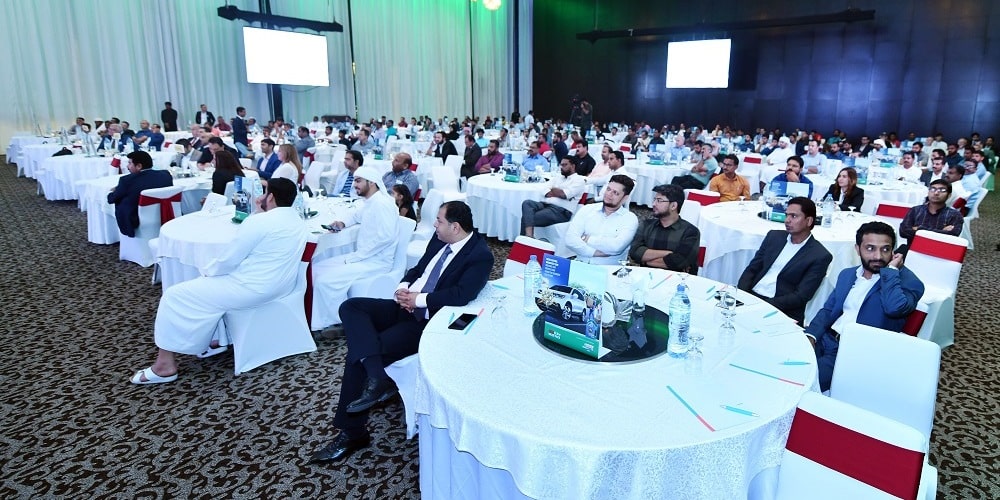 People on sitting on white chair with red ribbon in event