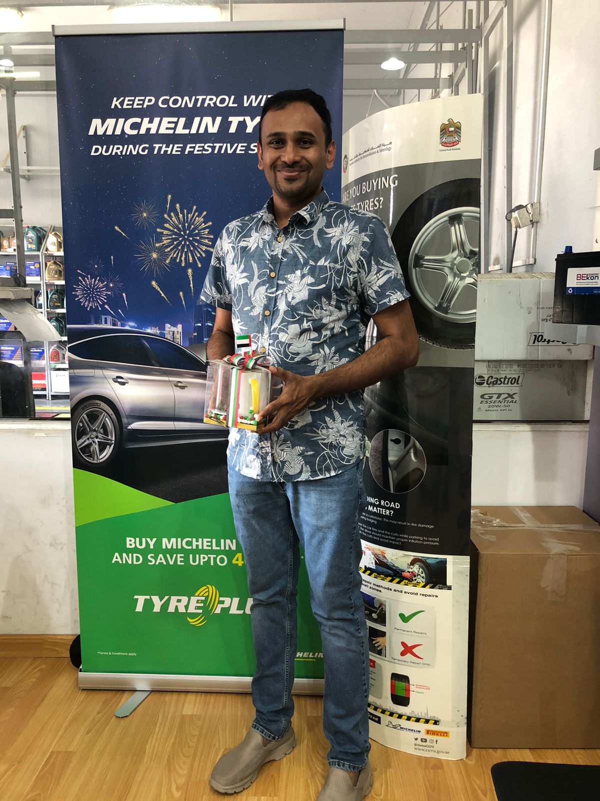 Man in flower shirt smiling on receiving a gift